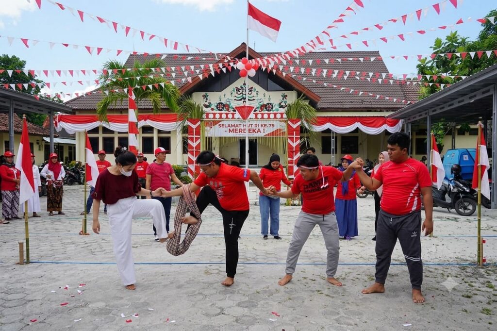 Warga mengikuti lomba estafet sarung sebagai permainan kelompok yang membangun kekompakan, sportivitas, dan semangat gotong royong.