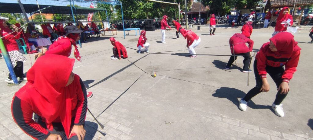 lomba memasukkan paku ke dalam botol sebagai permainan kelompok yang melatih fokus, koordinasi, dan kerja sama.