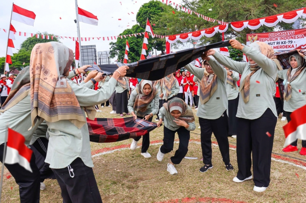 Participants carrying a ball using fabric as a team competition that improves coordination, communication, and teamwork