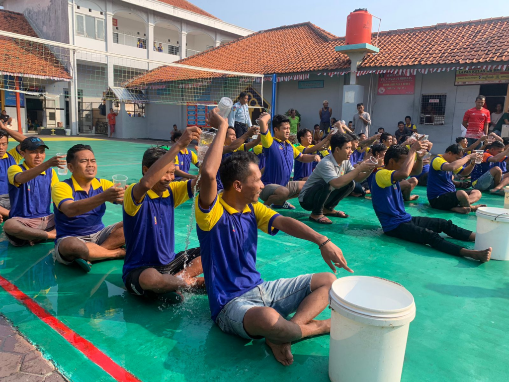 Residents participating in a group water relay competition during Independence Day celebration to improve teamwork and mutual cooperation spirit